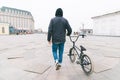 young man walking around the city with a BMX bike. Walk with a bike Royalty Free Stock Photo