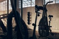 Spinning bike, empty and gym for exercise with a shadow background at a warehouse with light. Club, cardio bicycle for Royalty Free Stock Photo