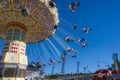 Spinning Carousel people blurred blue sky Sydney Easter show.