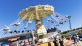 Spinning Carousel people blurred blue sky Sydney Easter show.