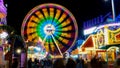 Spinning ferris wheel in motion on funfair. An abstract blurred background object image of ferris wheel at night Royalty Free Stock Photo