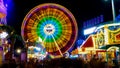 Spinning ferris wheel in motion on funfair. An abstract blurred background object image of ferris wheel at night Royalty Free Stock Photo