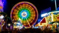 Spinning ferris wheel in motion on funfair. An abstract blurred image of ferris wheel at night Royalty Free Stock Photo