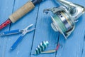 Spinning, reel, fishing green spoon and pliers. The bait and the tool of a fisherman. Royalty Free Stock Photo