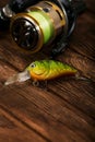 Spinning with a reel on an old brown wooden background. Fishing lure. Plastic bright green wobbler. Beautiful relief boards. Royalty Free Stock Photo