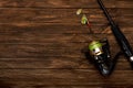 Spinning with a reel on an old brown wooden background. Metal Fishing lure. Beautiful relief boards. Carbon rod. Fishing. Summer. Royalty Free Stock Photo