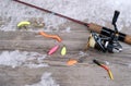 a spinning rod with a reel and fishing baits lies on a wooden table, top view Royalty Free Stock Photo