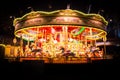 A spinning vintage carousel at night leaving colorful light trails
