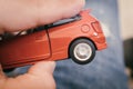 Spinning wheel on a tiny red toy car hold with a human hand Royalty Free Stock Photo