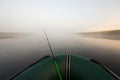 Spinning with wobbler on boat, on foggy morning river.