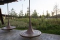 Spinning wooden bench and metal pergola. Walkway with grass lawn, bushes, plants, trees in background. Tyufeleva Roshcha city park Royalty Free Stock Photo