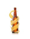 Spiral beer`s splash around brown bottle on a white background. Royalty Free Stock Photo