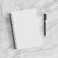Spiral-bound notebook with blank white pages on a marble surface Royalty Free Stock Photo