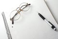 Spiral bound notebook with glasses and pencil Royalty Free Stock Photo