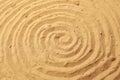 Spiral drawing on beach sand background. Royalty Free Stock Photo