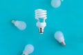 spiral energy saving light bulb and flying bulbs on blue background, energy saving and eco friendly life concept Royalty Free Stock Photo