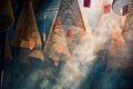 Spiral incense hanging from the ceiling in smoke with sun rays coming thru inside a buddism asian temple. Thien Hau temple. (Ho