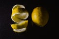 Spiral lemon peel and whole lemon on a glittery black glass background with room for some text Royalty Free Stock Photo