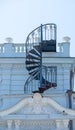 Spiral metal staircase on the wall of the house leading to the roof