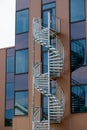 Spiral metal stairs acting as fire escape for a brown office building.. Royalty Free Stock Photo