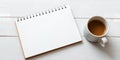 A spiral notebook with blank pages and a cup of coffee on a white wooden surface tabletop Royalty Free Stock Photo