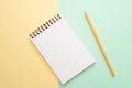 Spiral notebook with blank white sheet and colored pencil on multi-colored paper. Royalty Free Stock Photo