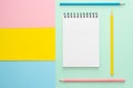 Spiral notebook with blank white sheet and colored pencils on multi-colored paper Royalty Free Stock Photo