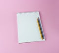 spiral notebook with blue and yellow pencil close-up on pink background Royalty Free Stock Photo