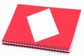 Spiral notebook with red cover and white card on white background Royalty Free Stock Photo