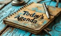 Spiral notebook with Todays Agenda on the cover, accompanied by a pen on a wooden surface, representing organization and Royalty Free Stock Photo