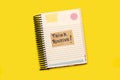 Spiral notepad with a sticky paper with Think Positive short phrase handwritten on it on a yellow background Royalty Free Stock Photo