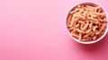 Spiral pasta in bowl on minimalist pink background with copy space on the side, italian food concept