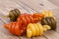 Spiral pasta trottole tricolore on wooden plank