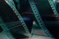 Spiral retro film strip on wooden surface in soft green light. Twisted analog old strips of film for photo or video Royalty Free Stock Photo