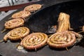 Spiral-rolled sausages ready to eat, grilled or roasted in a barbecue on an open fire and flames Royalty Free Stock Photo