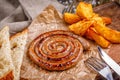 Spiral sausage grilled. with golden crispy delicious french fries. Fast food in the restaurant. Delicious fried spiral