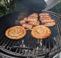 Spiral sausages and Romanian mititei seasoned on the grill for frying Royalty Free Stock Photo