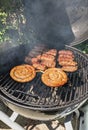 Spiral sausages and Romanian mititei seasoned on the grill for frying Royalty Free Stock Photo