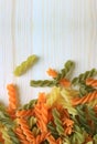 Spiral Shaped three-color fusilli pasta on natural wooden table, vertical photo with free space for text Royalty Free Stock Photo