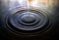 Spiral shaped water drop on calm water background