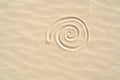 Spiral shell drawn on the sand on the beach top view with copy space Royalty Free Stock Photo