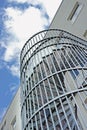 A spiral staircase on the outside of a building. Grey steel spiral stairs built on the side of modern industrial office Royalty Free Stock Photo