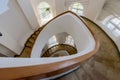 Spiral staircase with yellow banisters and white walls