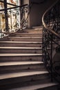 Spiral stone staircase with white granite steps and railings with forged metal patterns Royalty Free Stock Photo