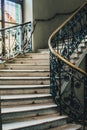 Spiral stone staircase with white granite steps and railings with forged metal patterns Royalty Free Stock Photo