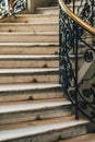 Spiral stone staircase with white granite steps and railings with forged metal patterns Royalty Free Stock Photo