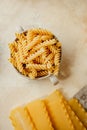 Spiral tortiglioni pasta and raw hard homemade fluted lasagna sheets in flour close-up. real life atmosphere. homemade pasta made