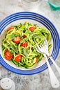 Spiralled courgette with green pesto and cherry tomatoes