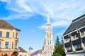 Spire of the Matthias Church in Budapest, Hungary on a horizontal photo with adjacent Socialist building. Roman Catholic church