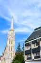 Spire of the Matthias Church in Budapest, Hungary on a vertical photo with adjacent Socialist building. Roman Catholic church Royalty Free Stock Photo